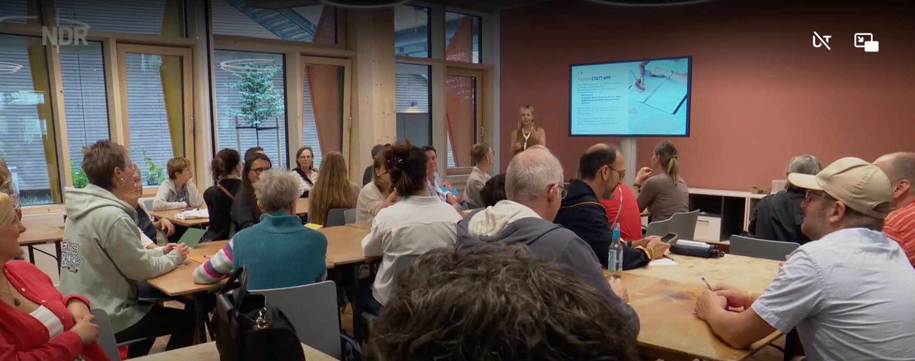 Juliane Schreiber präsentiert im NDR Hamburg Journal vor Workshop-Teilnehmenden