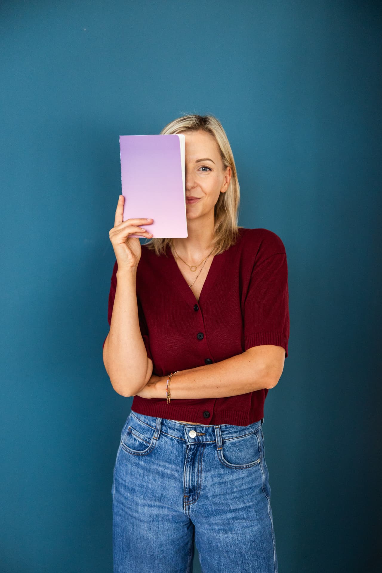 Juliane Schreiber hält ein lila Notizbuch vor eine Gesichtshälfte